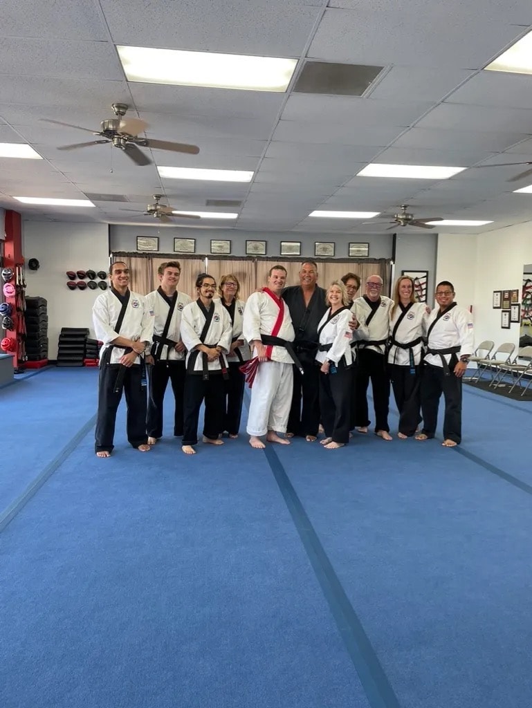 Large group of black belts posing in dojo