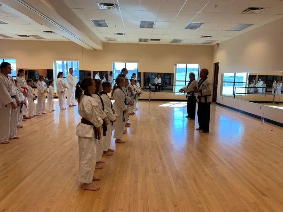 Karate class students in white uniforms training