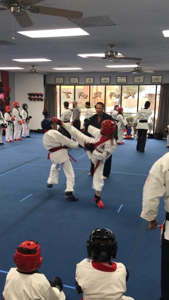 Children sparring in taekwondo class indoors