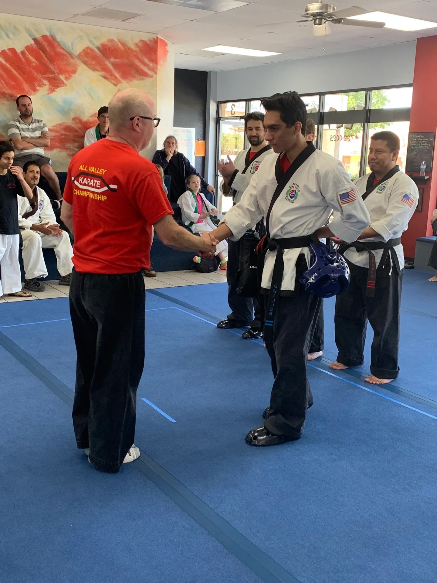 All Valley Karate Championship instructor shaking hands with student on mat