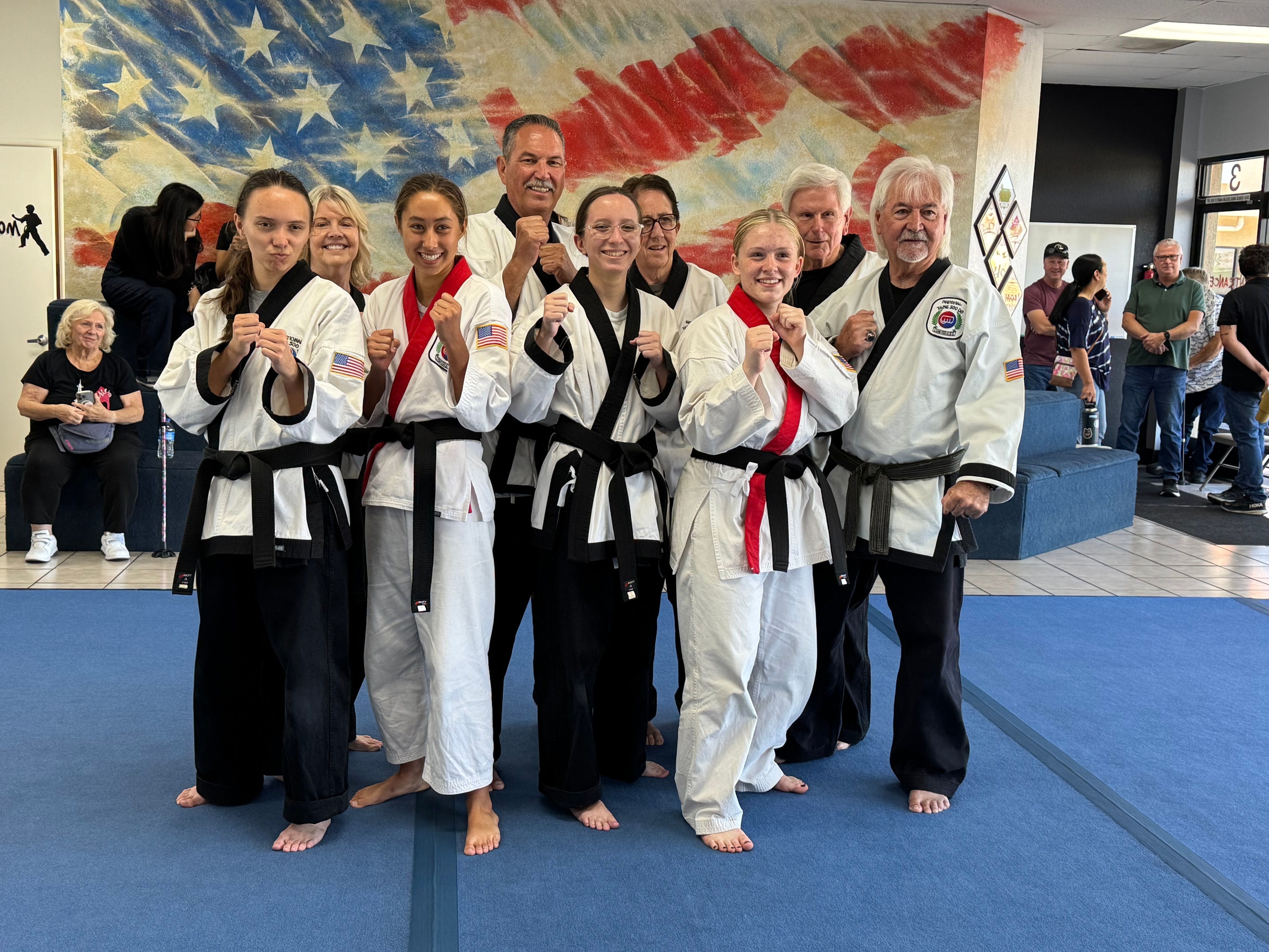 Karate black belt group photo in front of American flag backdrop