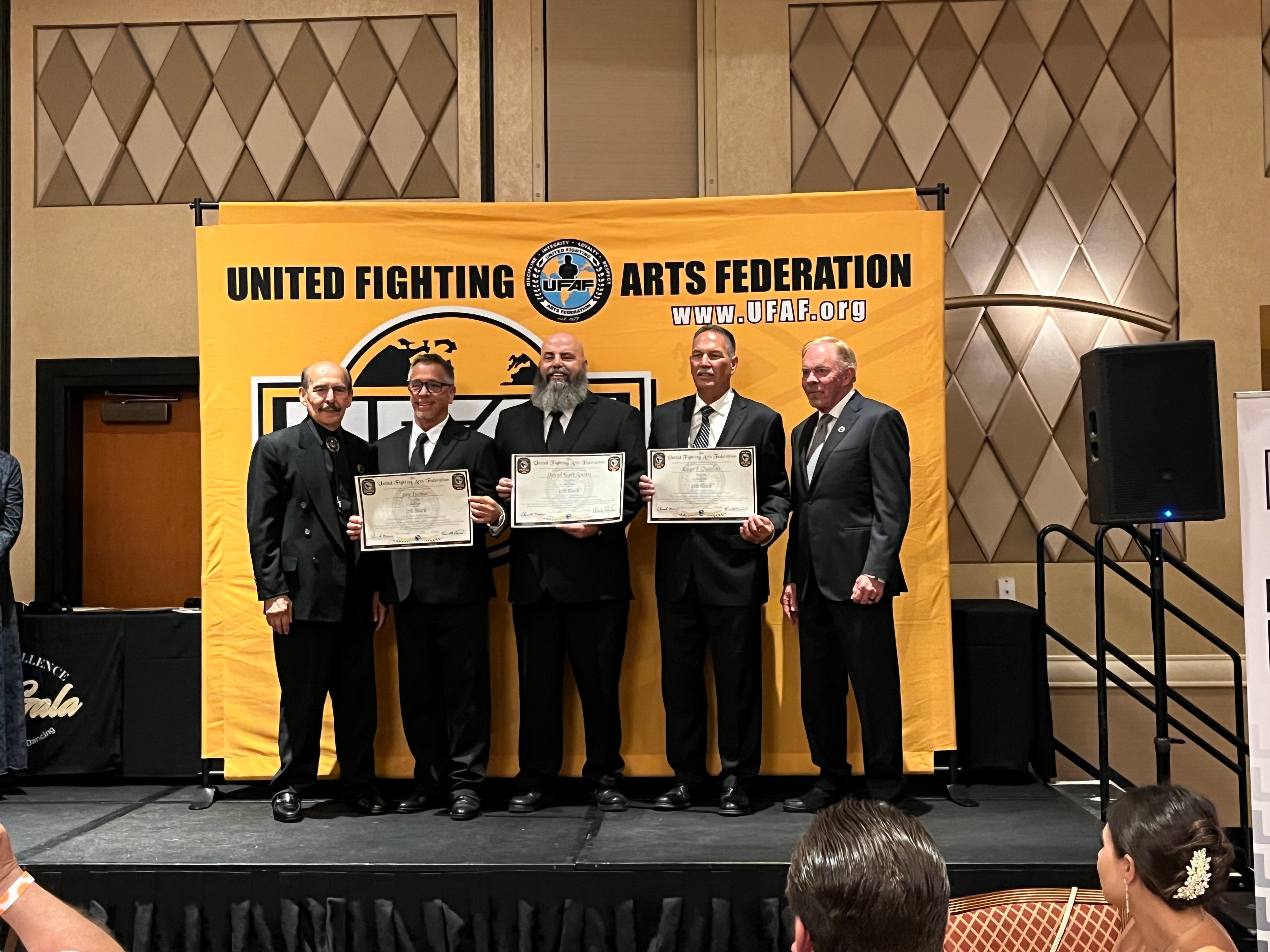 Five men at United Fighting Arts Federation UFAF award ceremony on stage