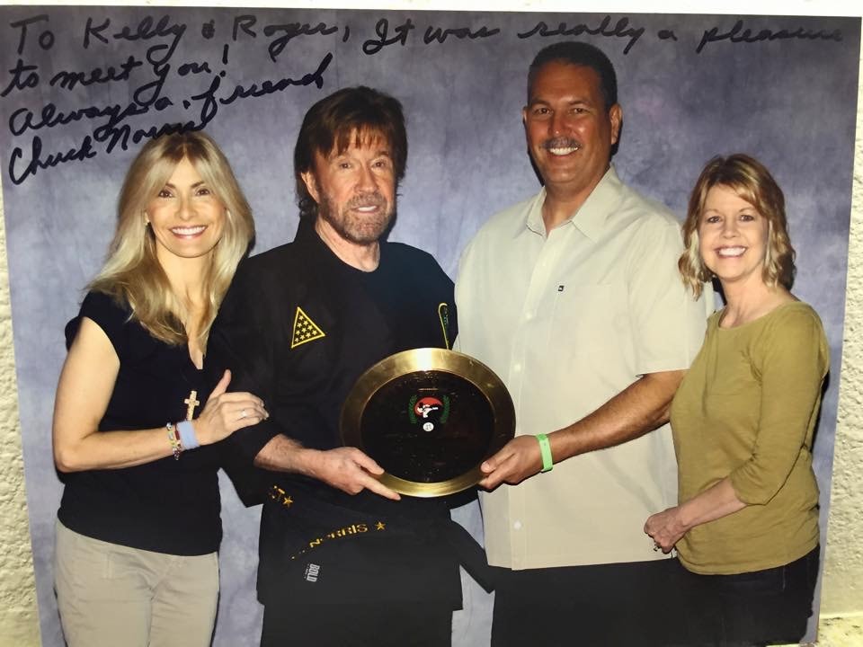 Signed photo of Chuck Norris with Kelly and Roger holding championship award
